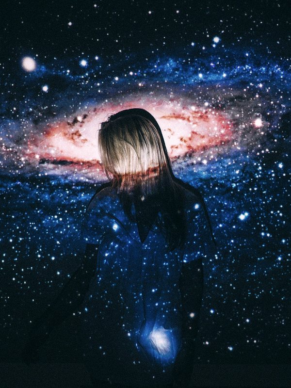 A figure standing before a projected galaxy